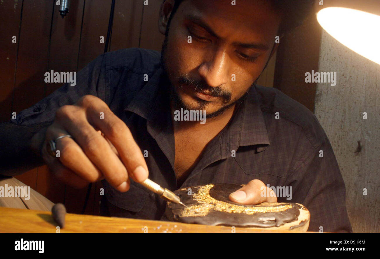 Jeweler busy in preparing gold jewelries at his workshop while The per tola price of gold saw an Rs 1,800 decrease and is now being sold at Rs 50,500 in the local market at Sarafa Market in Karachi on Thursday, June 20, 2013. On the London Bullion Market, the price of gold tumbled as low as $1,287.91 an ounce as the dollar weakened the  precious metal striking a point last seen in late September 2010. Stock Photo