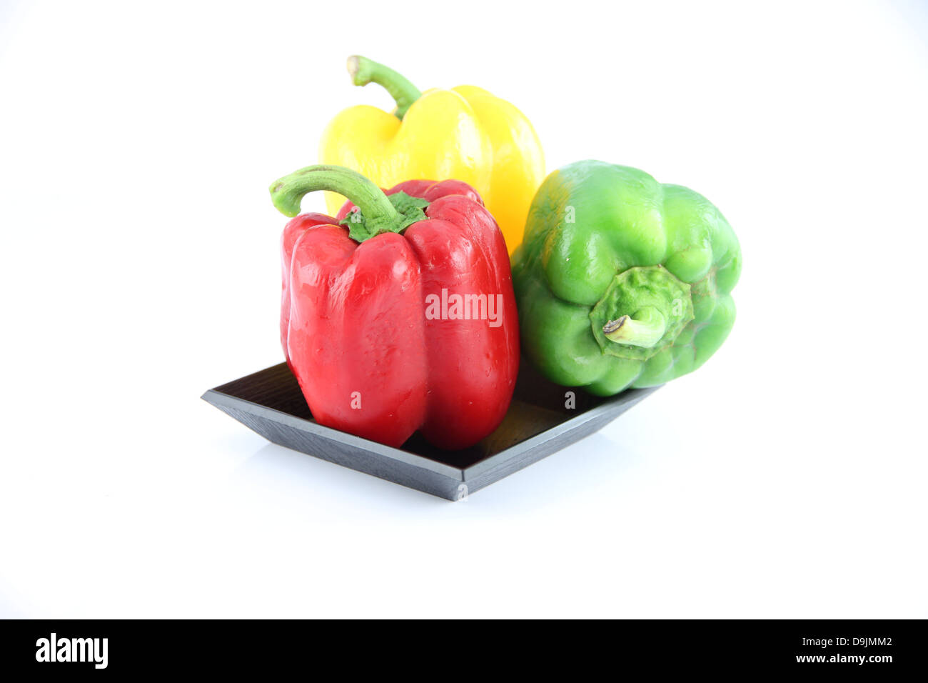 Three color of Bell pepper in a black dish on the white background. Stock Photo