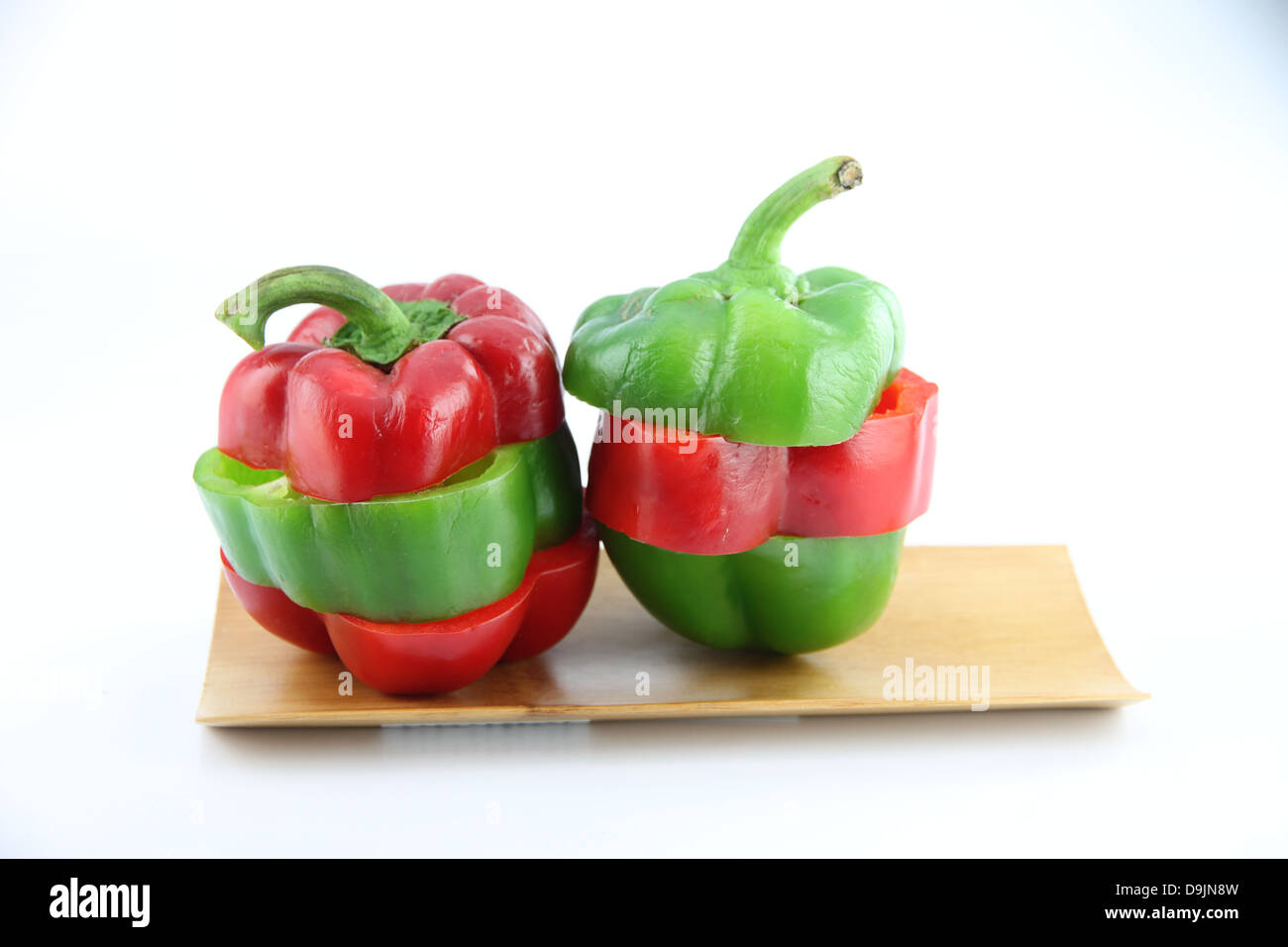 Slice the Three color of bell pepper in the Bamboo dish on white background. Stock Photo