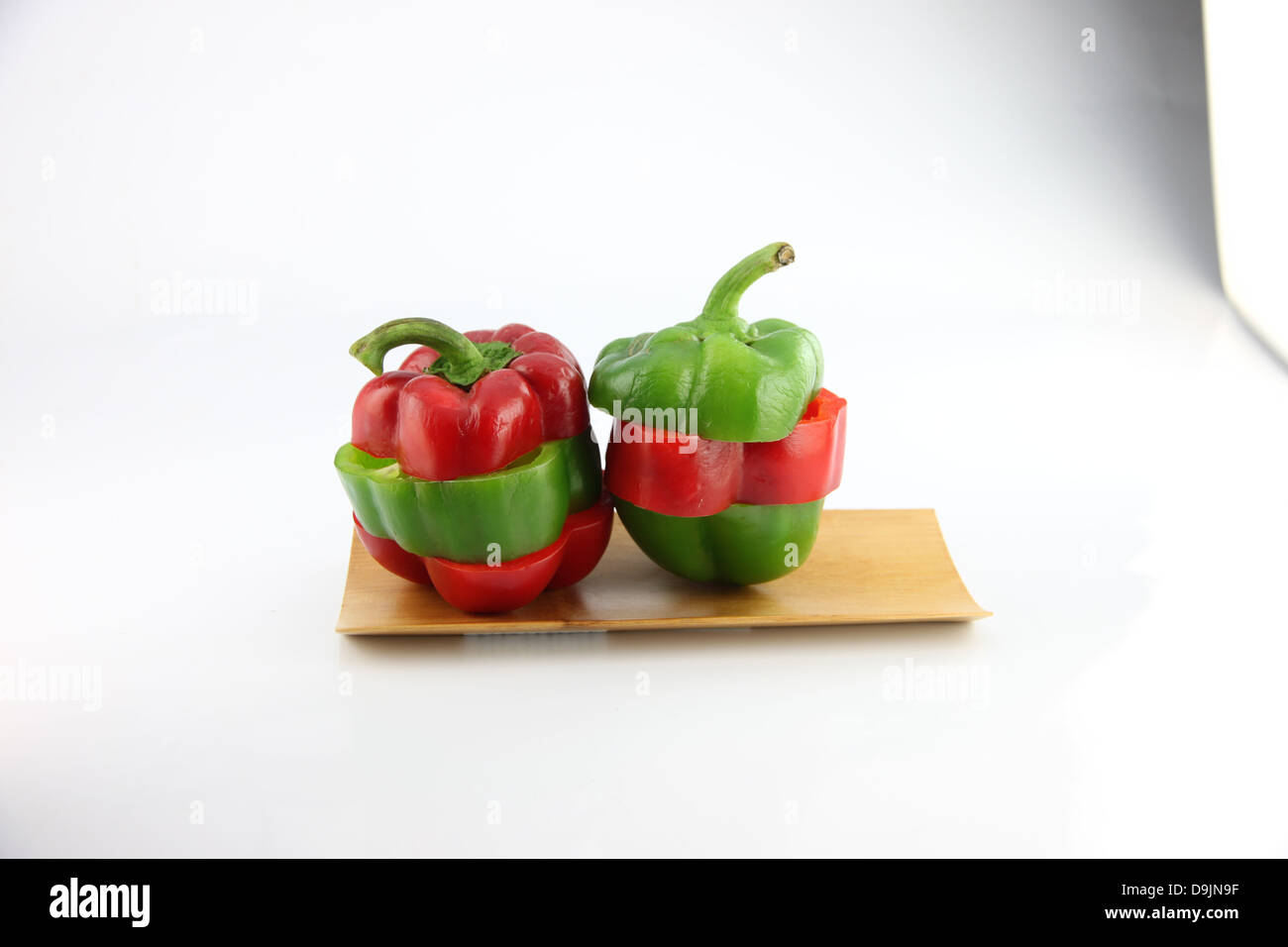 Slice the Three color of bell pepper in the Bamboo dish on white background. Stock Photo