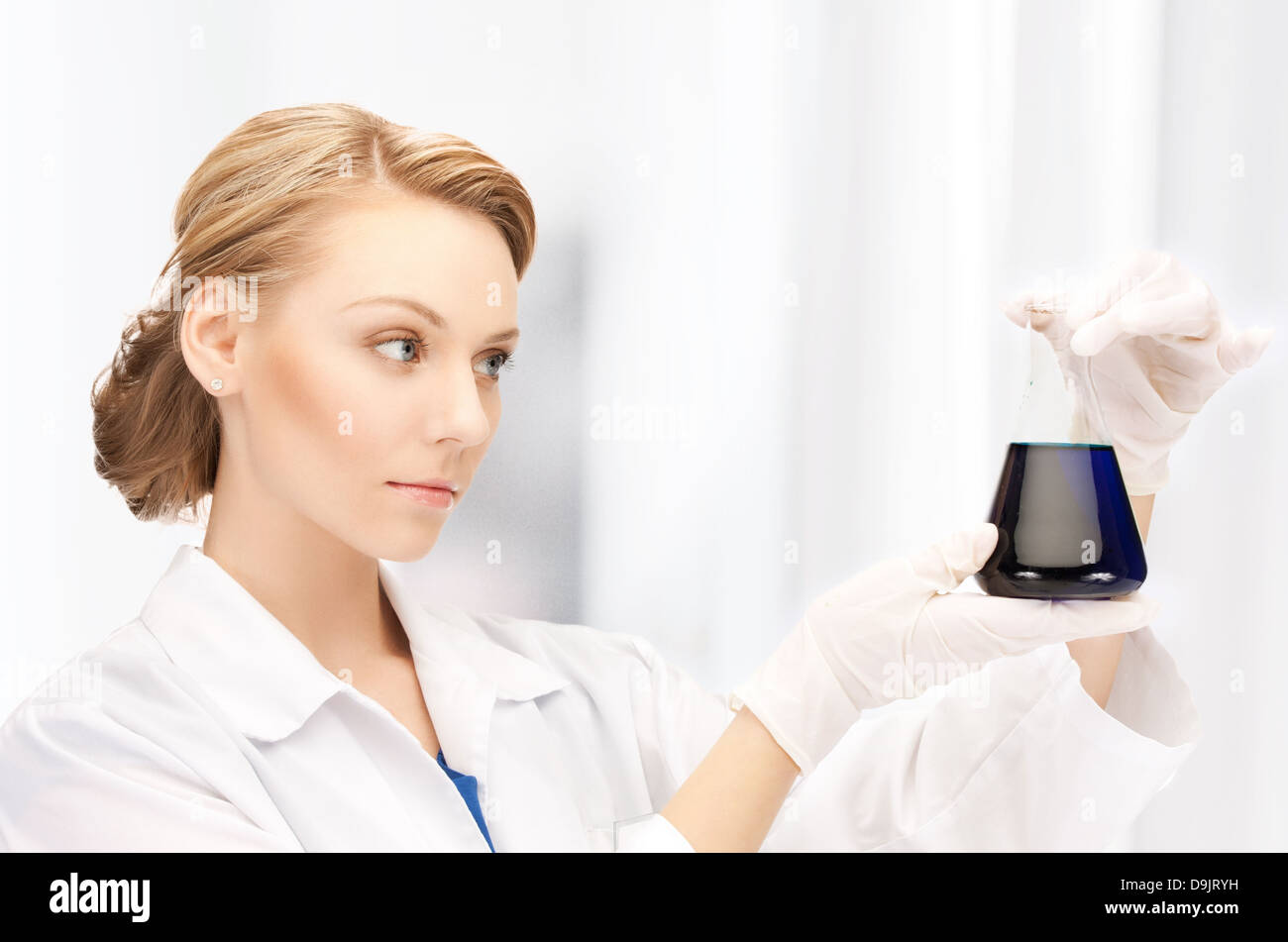 female chemist holding bulb with chemicals Stock Photo