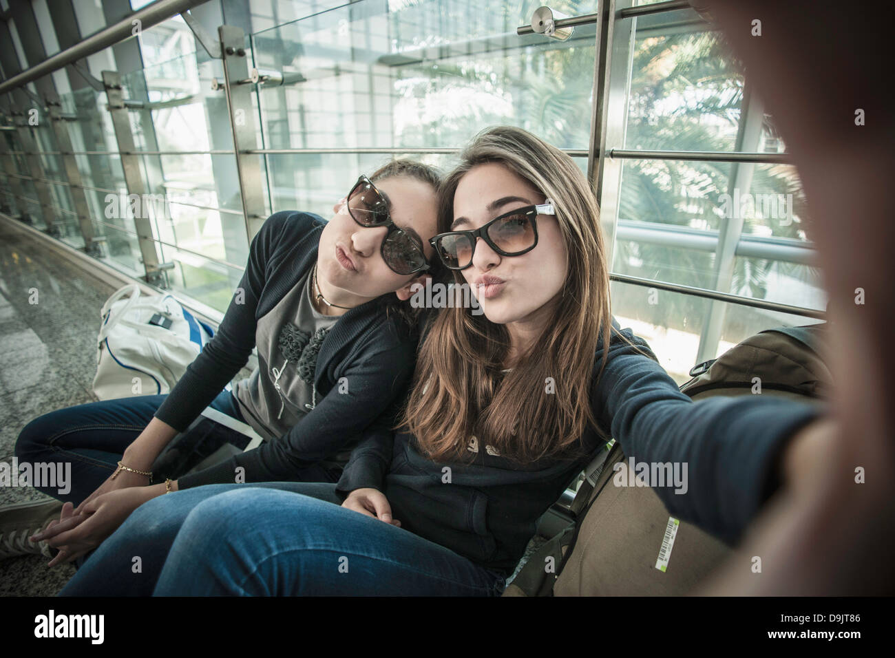 Two teenage girls posing to camera, photographing themselves Stock Photo