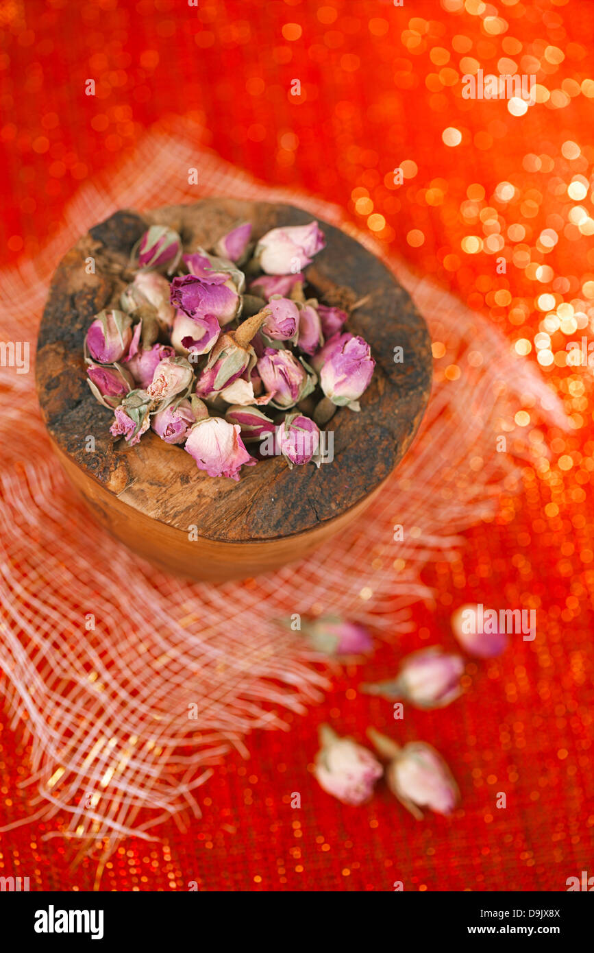 rose tea buds in wooden bowl, red glitter background, shallow dof Stock ...
