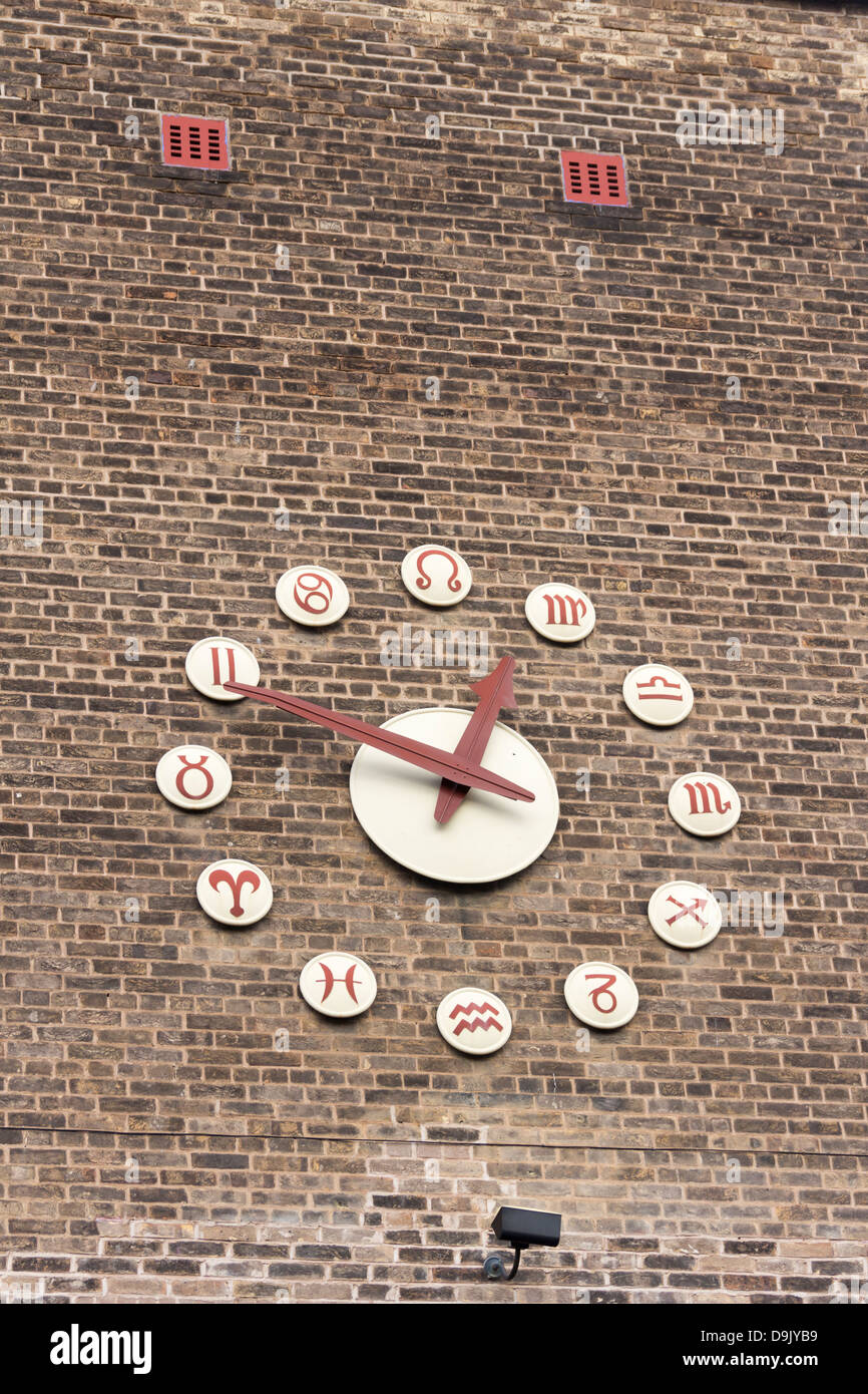 Clock with twelve Zodiac symbols in place of numbers on a shop building in St Helens. Stock Photo