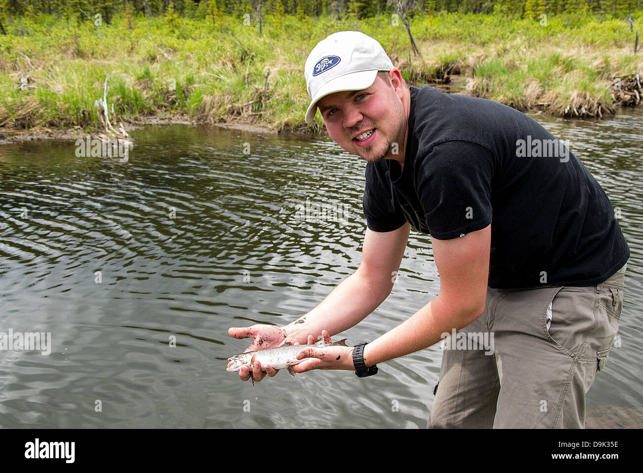Fly fisherman showing off fresh catch of a brook trout Stock Photo