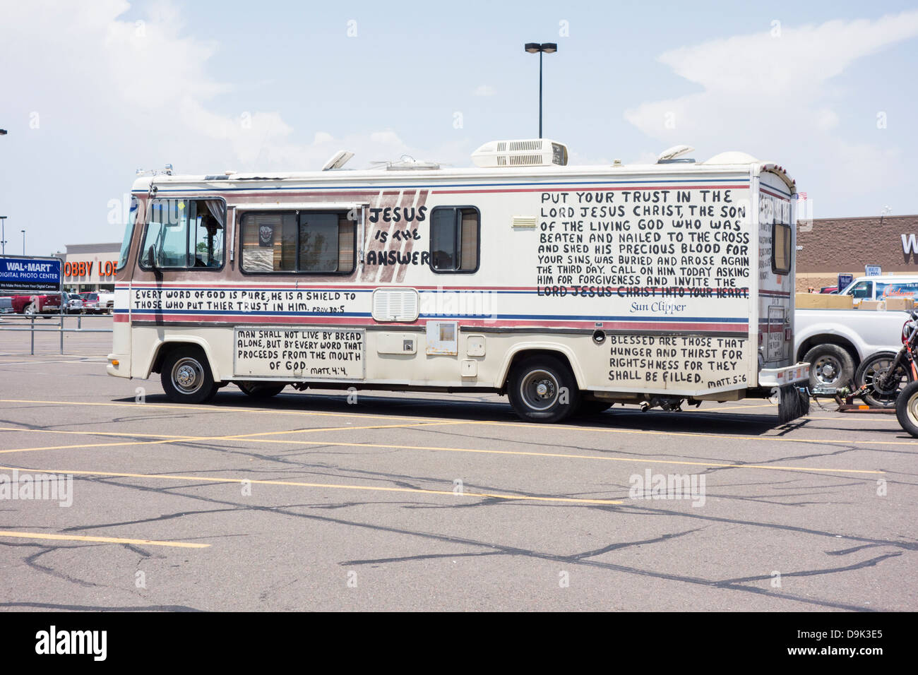 A recreational vehicle with biblical scripture painted all over it, along with solicitation for money. Walmart parking lot in Oklahoma City, OK, USA. Stock Photo