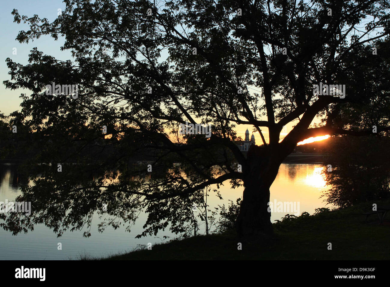 sunset sunrise silhouette sun sunshine water Lock Haven, Clinton County, Susquehanna River, horizontal tree, building Stock Photo
