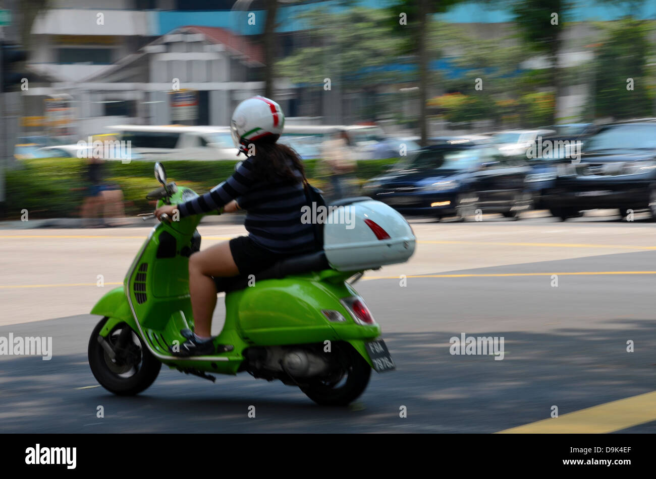 Lady on Vespa scooter speeds through intersection Stock Photo - Alamy