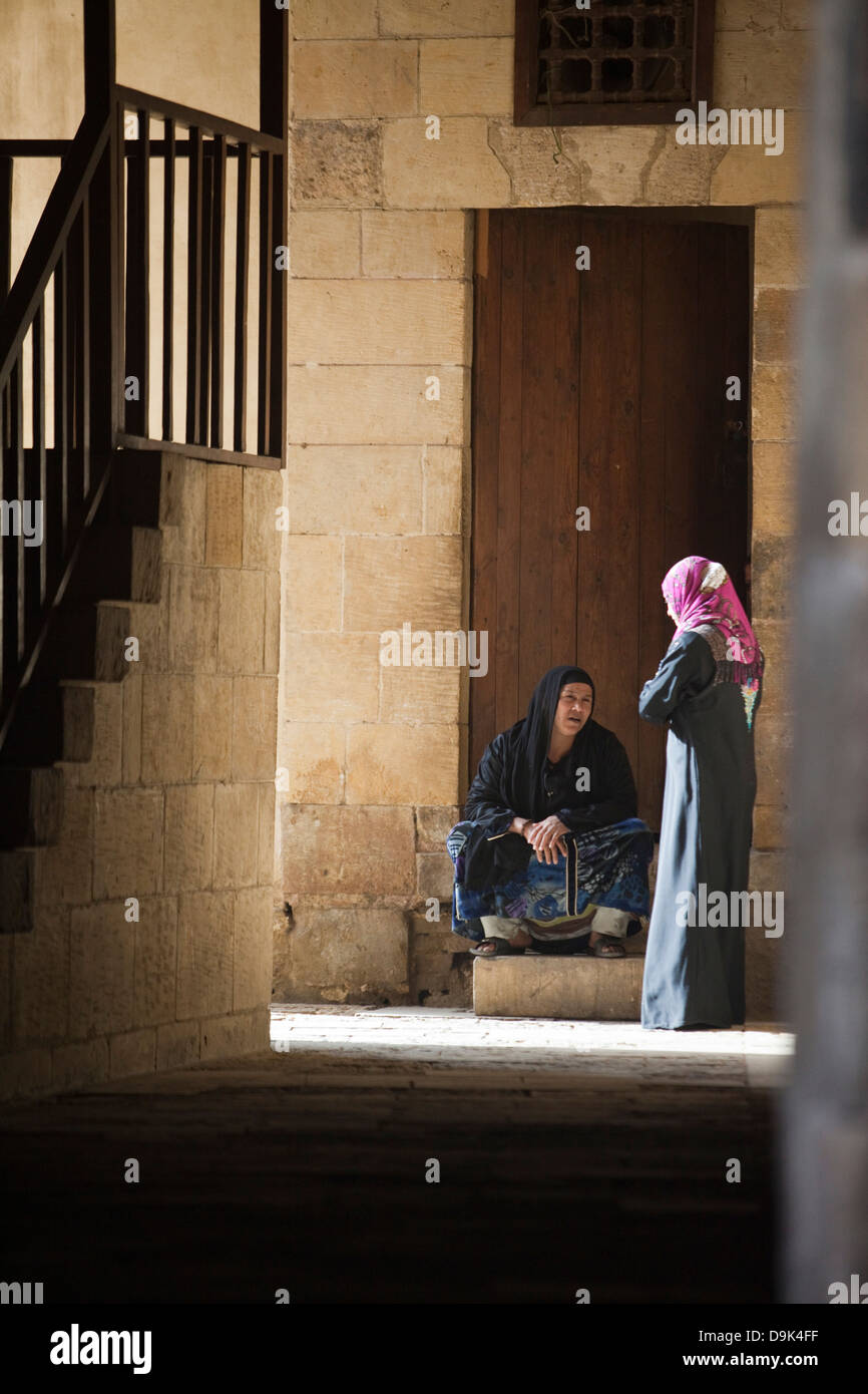 Two women talk in an alleyway, Bein al-Qasreen area, Islamic Cairo, Cairo, Egypt Stock Photo
