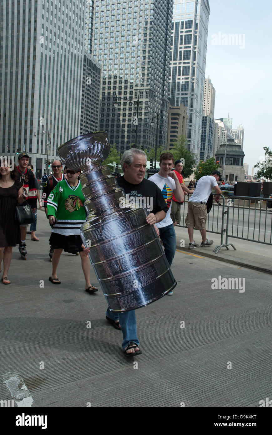 Jun 11, 2010 - Chicago, Illinois, U.S. - Fan carries fake Stanley cup on Wacker Drive. Parade on Michigan Avenue to celebrate the Stanley Cup 2010 championship win of the Chicago Blackhawks hockey team. Chicago Blackhawk players and organization members ride on top of English double decker buses greeting the crowd that has gathered to honor them. (Credit Image: © Karen I. Hirsch/ZUMAPRESS.com) Stock Photo