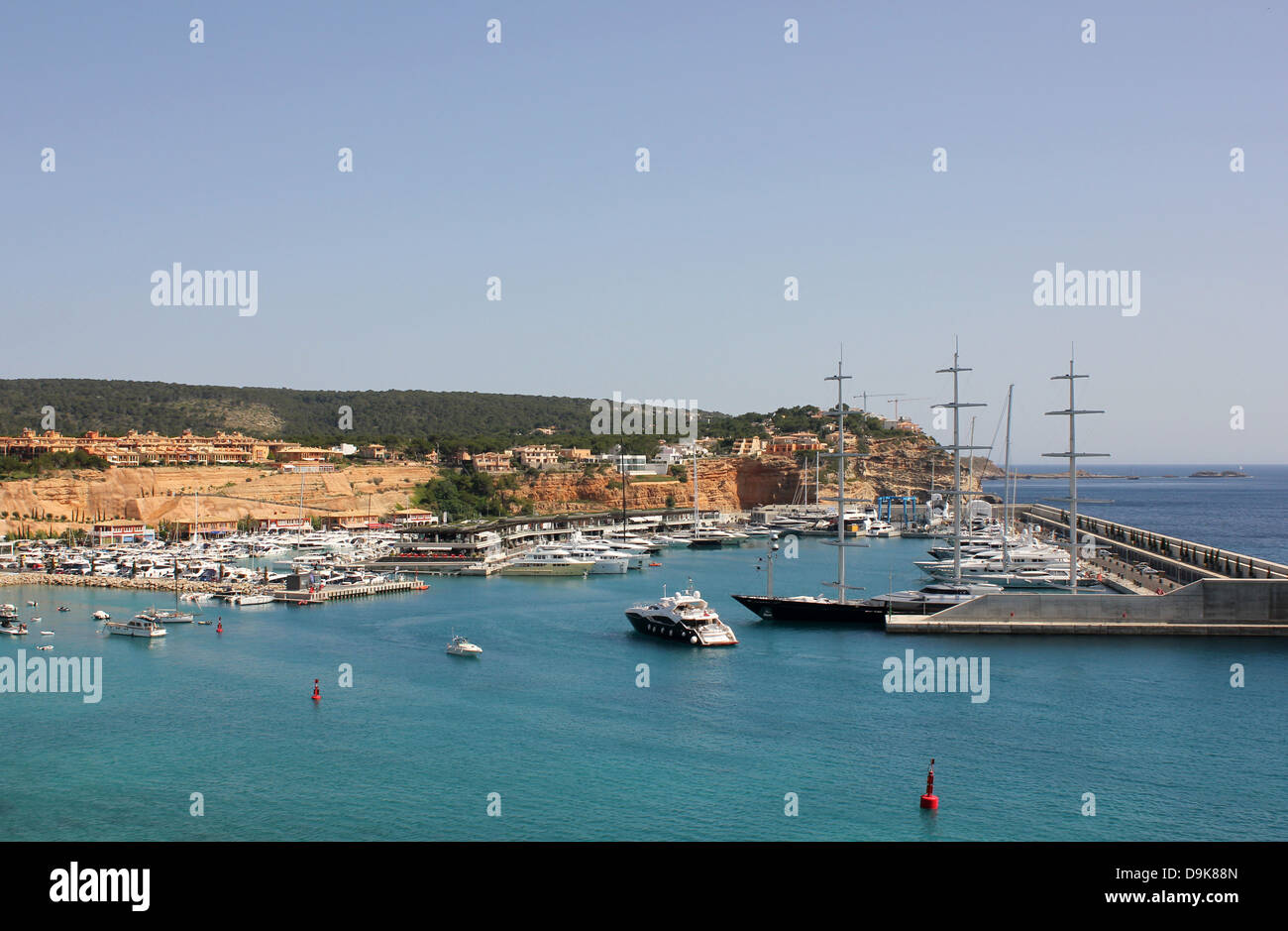 View over Port Adriano marina - luxury motor yacht entering marina past 'Maltese Falcon' Mallorca Stock Photo