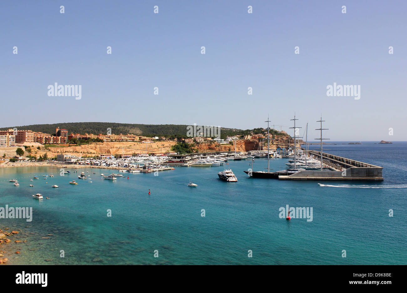 View over Port Adriano marina - luxury motor yacht entering marina past 'Maltese Falcon' - Mallorca. Stock Photo