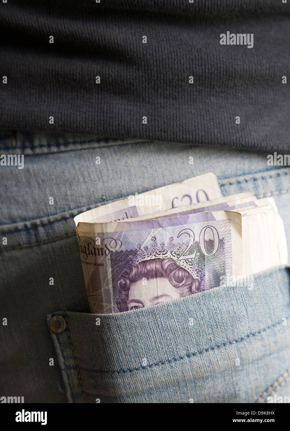 Roll of twenty pound notes in back pocket of denim jeans Stock Photo