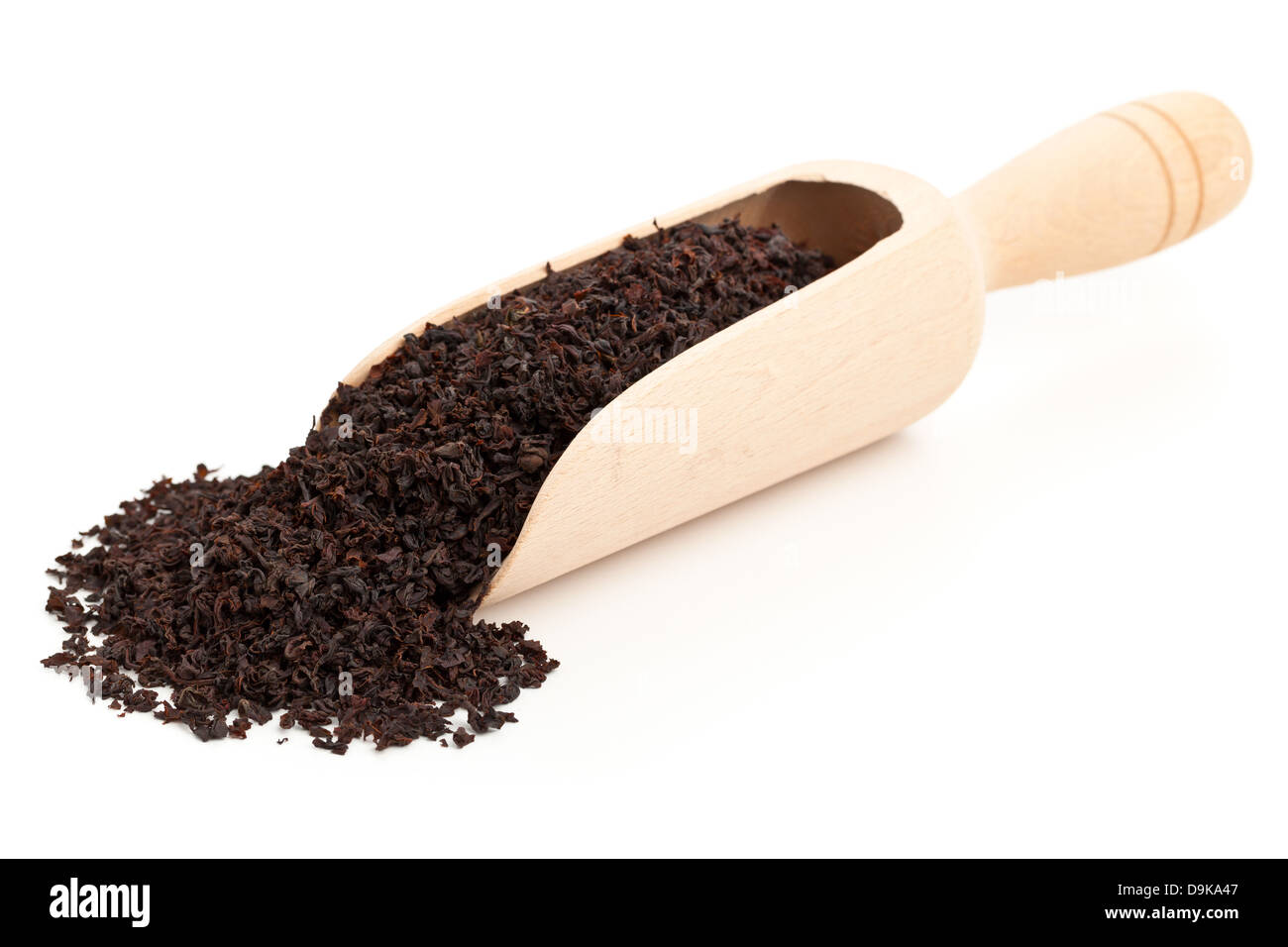Ceylon black tea crop in wooden scoop over white background Stock Photo