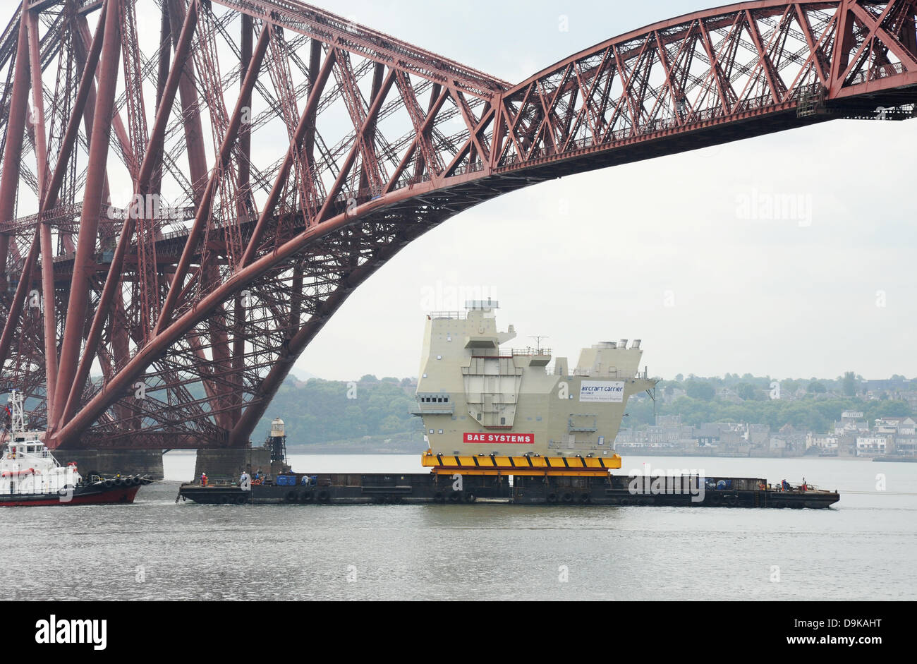 The Forth, near Edinburgh, UK. 21st June, 2013. Final piece of new aircraft carrier entering under the Forth Bridge near Rosyth. The section of aircraft carrier was built in Scotstoun and was being taken to the Rosyth dockyard for completion. Stock Photo