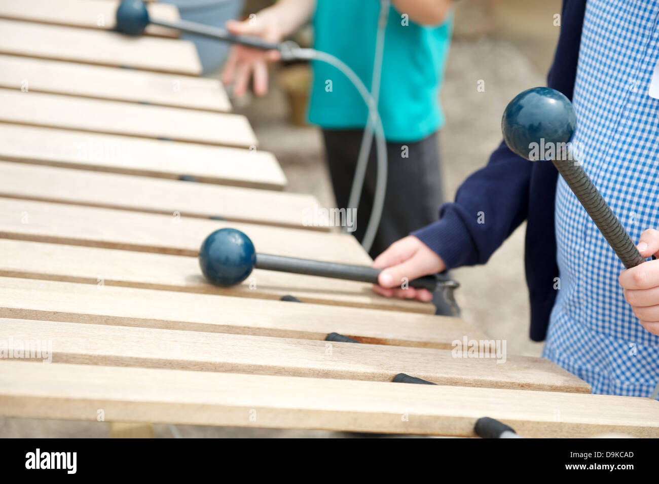 Two schoolchildren play a giant xylophone in the playground Stock Photo