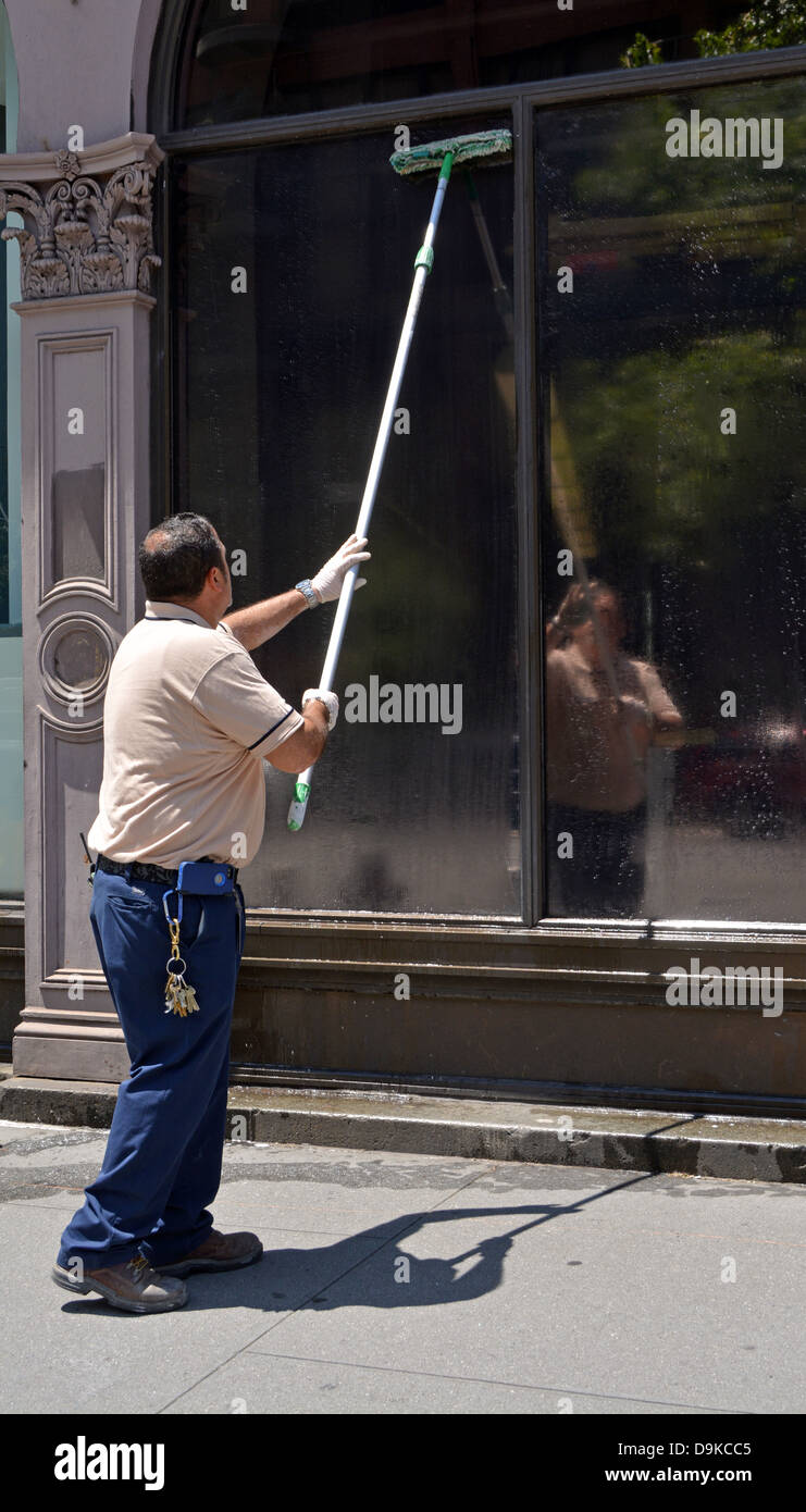 Photo of a man washing windows at Copper Union College in Greenwich Village, New York City Stock Photo