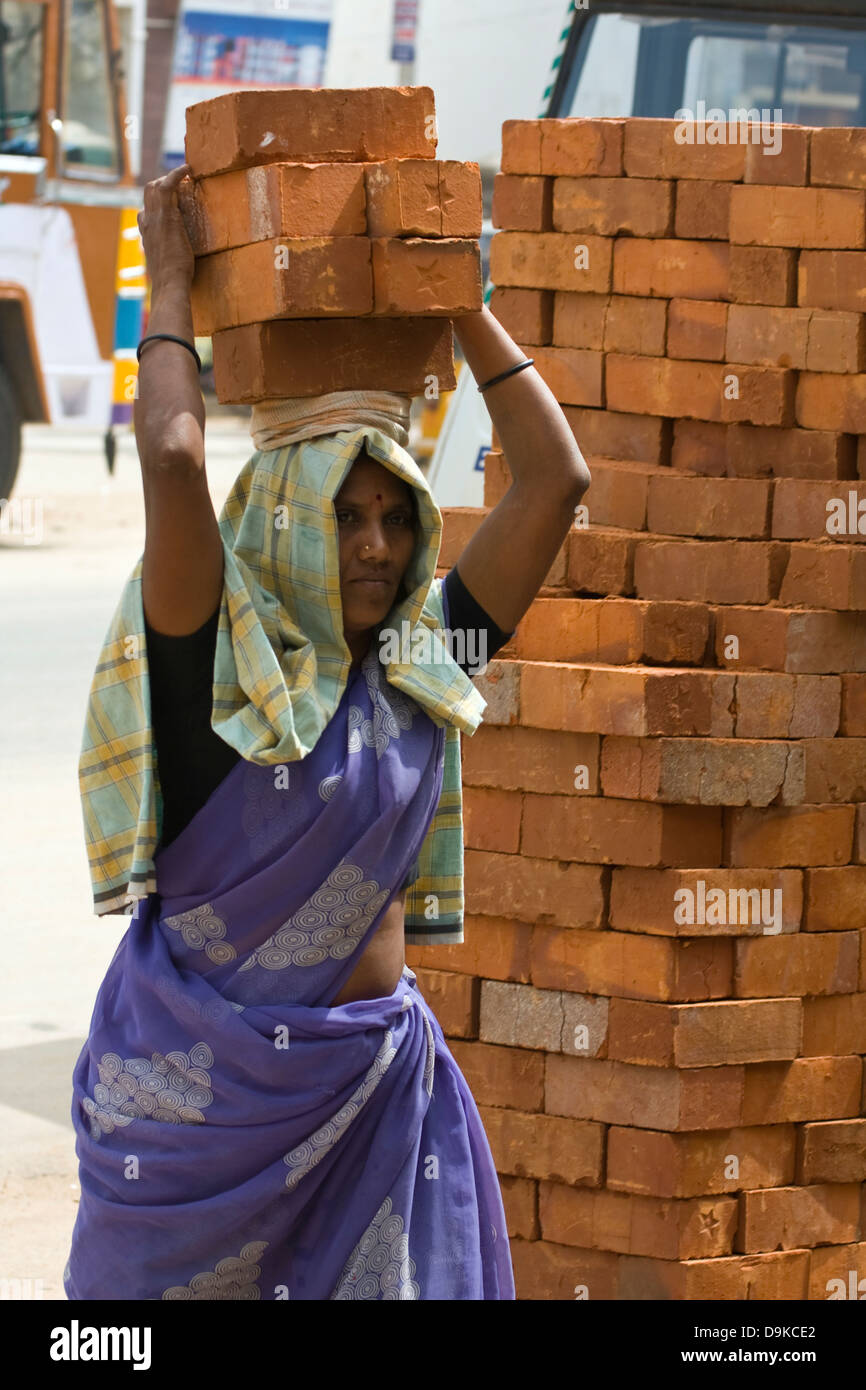 Asia, India, Tamil Nadu, Kanchipuram, a female construction worker carries bricks on her head Stock Photo