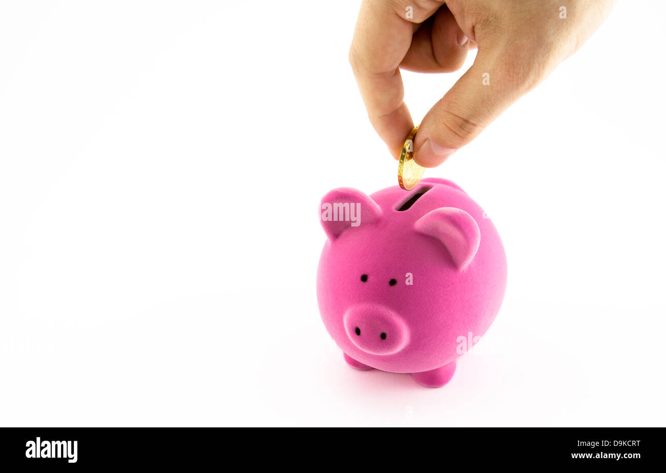 Pink piggy bank and hand with coin Stock Photo - Alamy