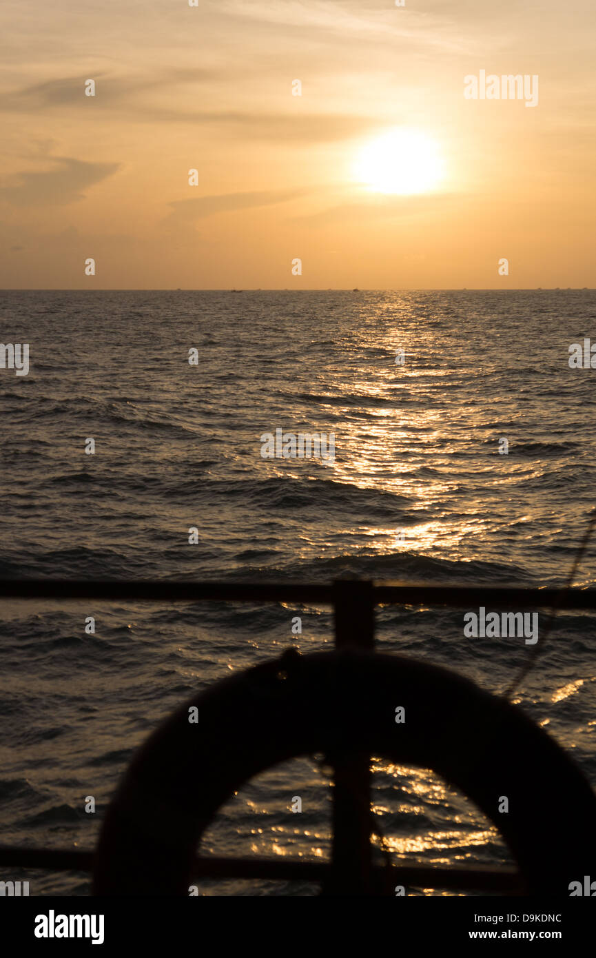 View from ship deck of setting sun, India Stock Photo
