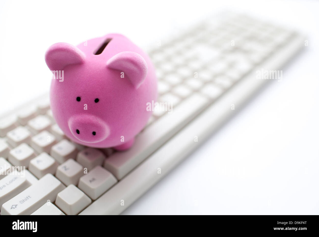 Pink piggy bank on computer keyboard Stock Photo - Alamy