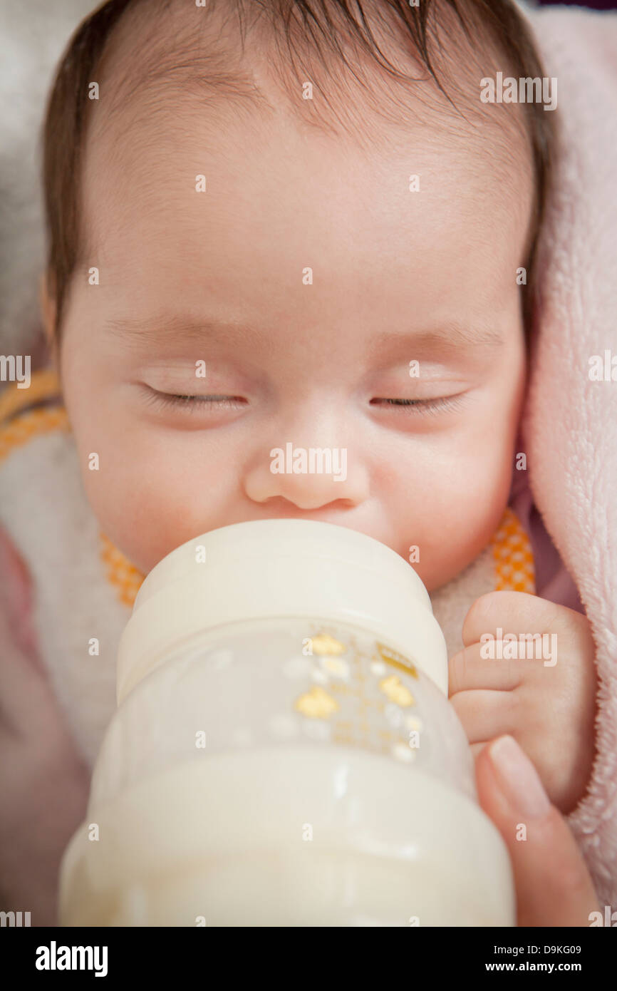 newborn baby girl with baby bottle Stock Photo