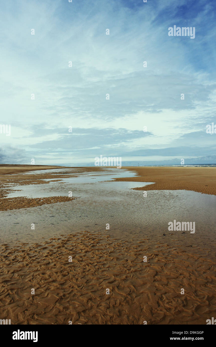 A stream of water running through some sand Stock Photo - Alamy