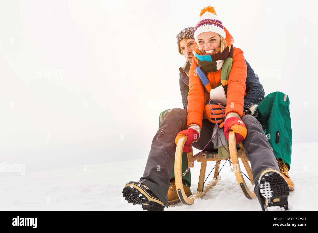 Couple on toboggan in snow Stock Photo Alamy
