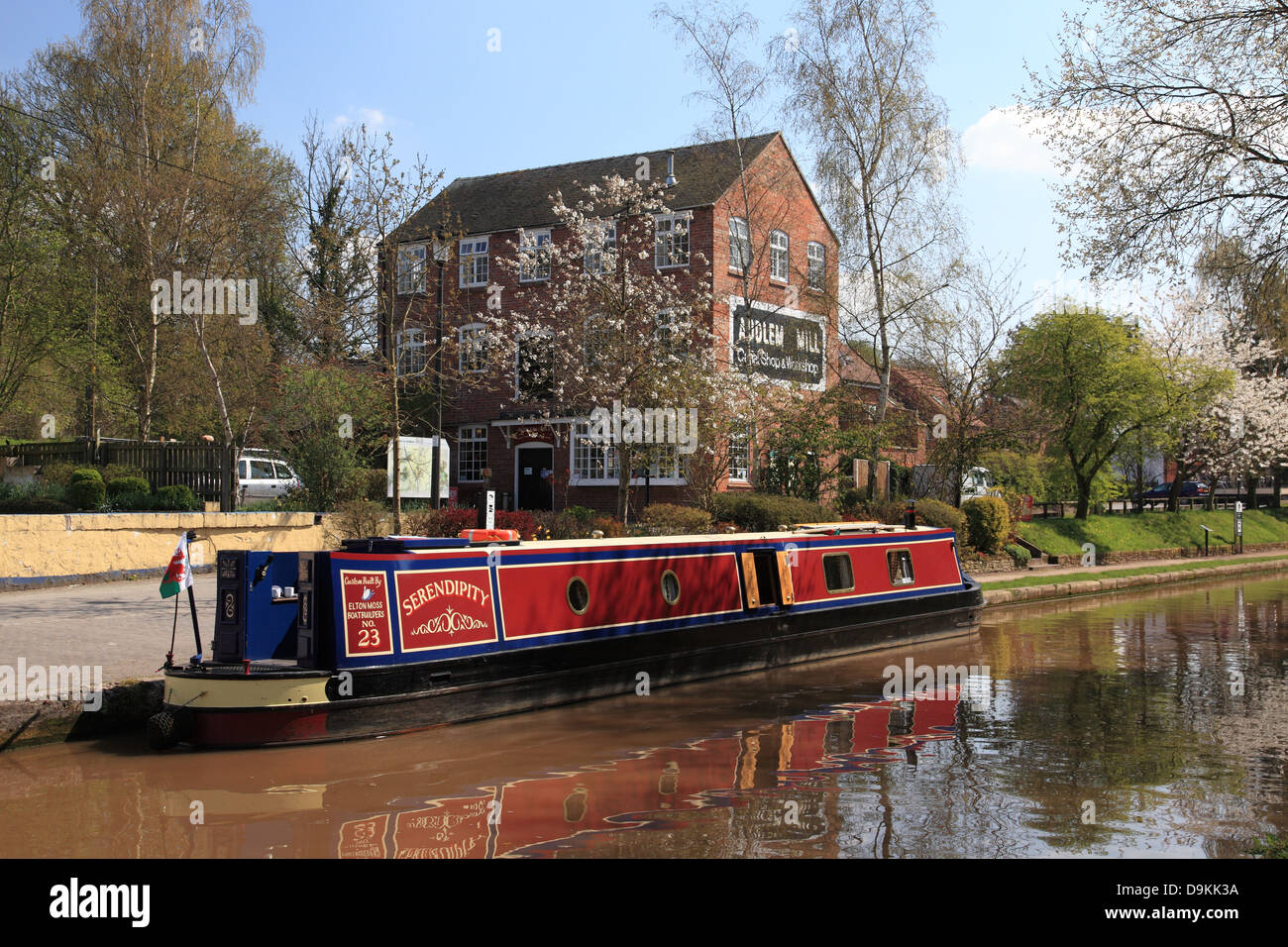 A narrowboat moored in front of Audlem Mill, a canal shop right next to the Shropshire Union Canal in Audlem, Cheshire Stock Photo