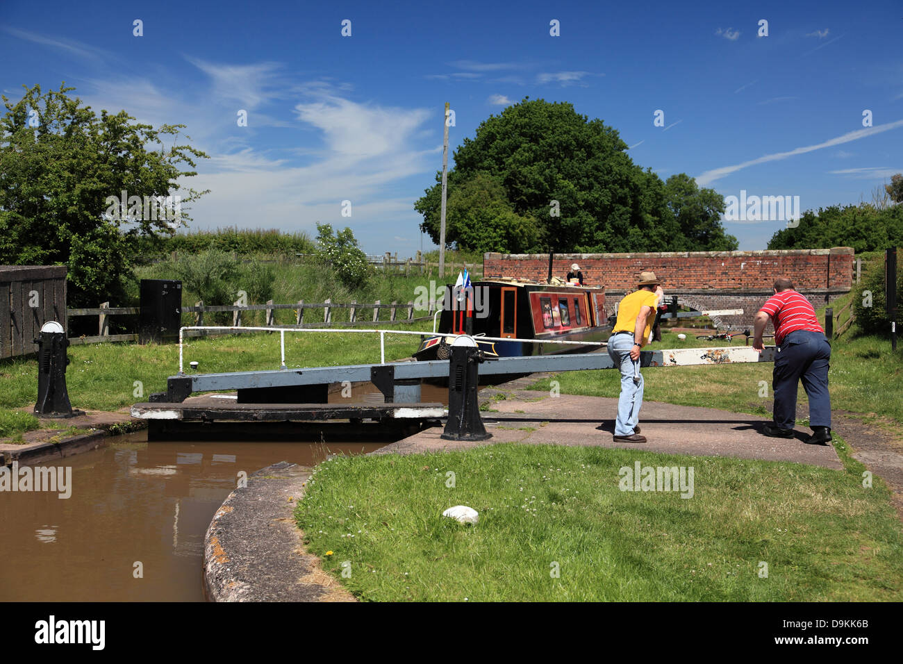 Boaters working the balance beam of the top lock of the Audlem flight of 15 locks on the Shropshire Union Canal Stock Photo