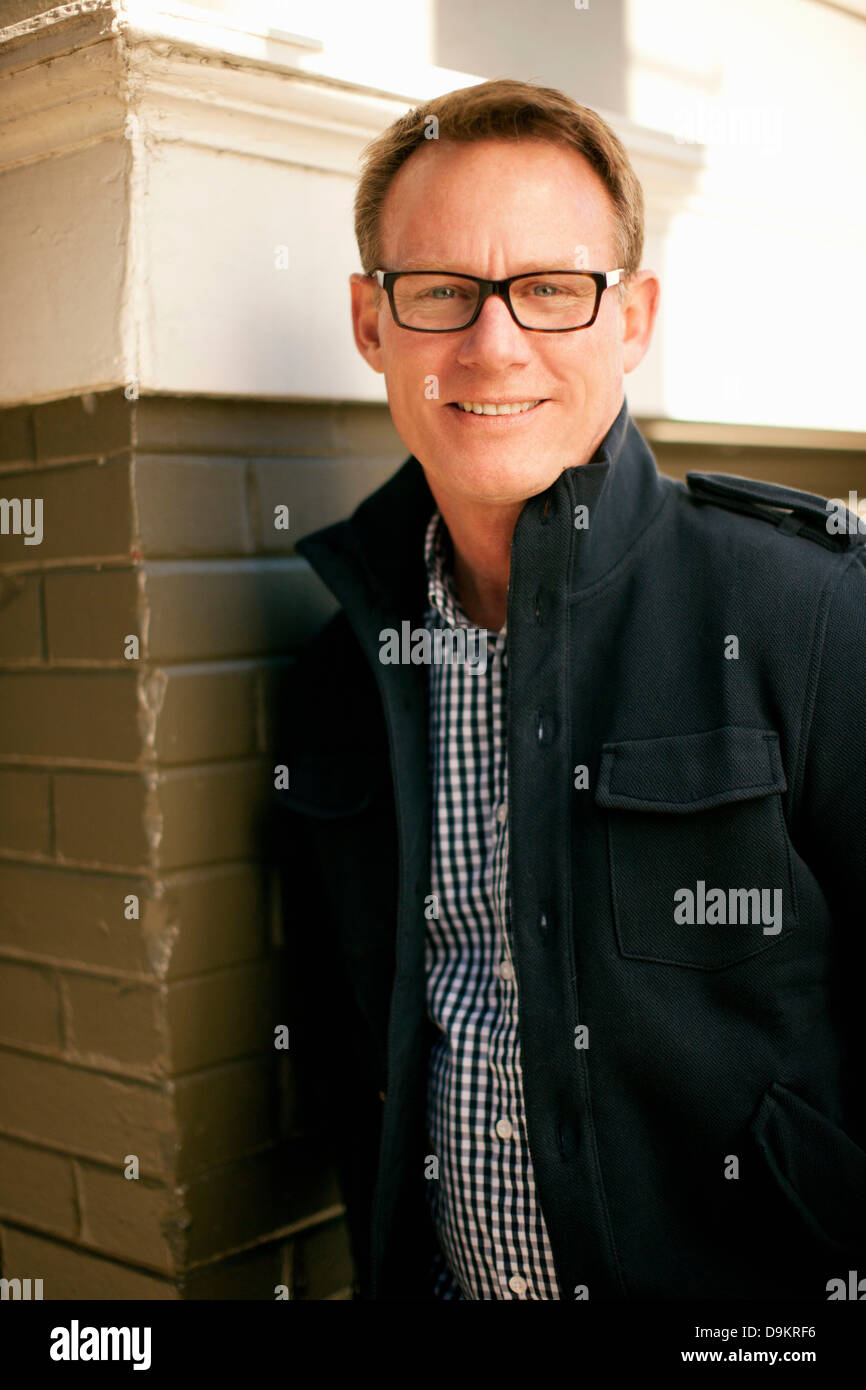 Man standing against brickwall Stock Photo