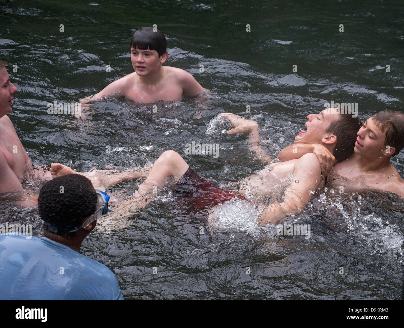 Teenage boys roughhouse in the waters of Manatee Springs State Park along the Suwannee River in North Florida. Stock Photo