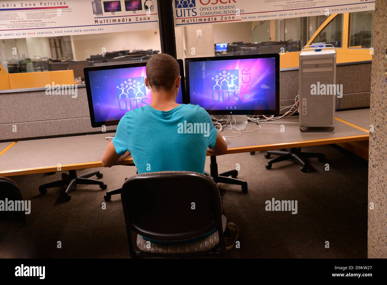 A young man works on a computer in a media center on a college campus. Stock Photo