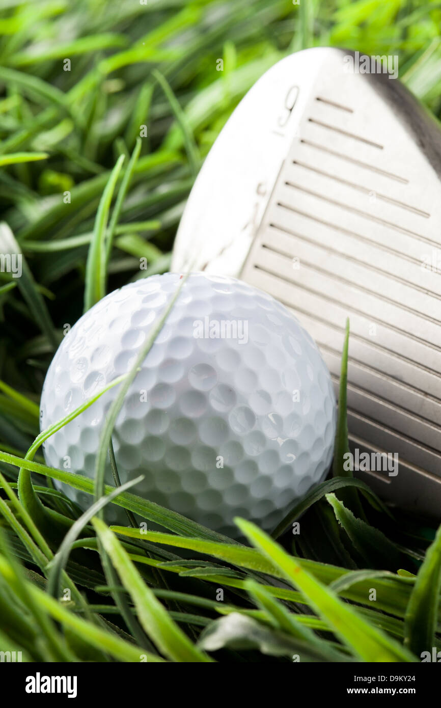 Pure White Golfball on bright green grass with a golfclub Stock Photo