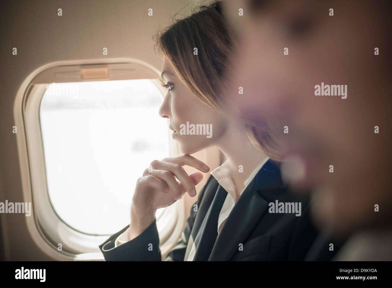 Female passenger looking out of aeroplane window Stock Photo