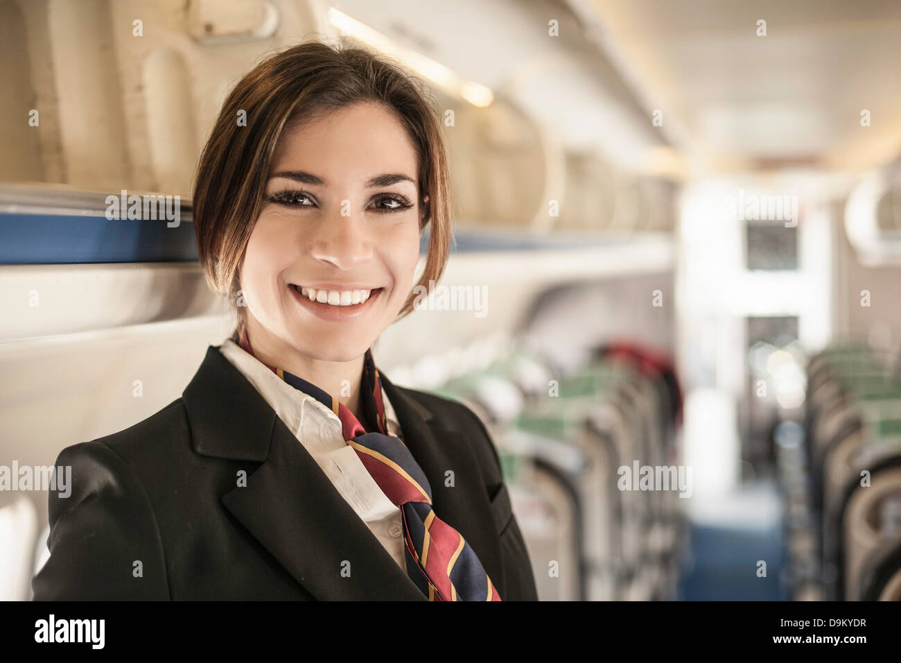 Portrait of air stewardess on aeroplane Stock Photo