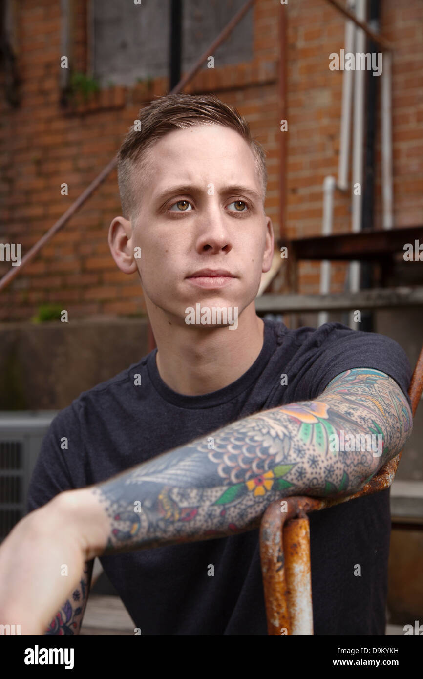 Young tattooed man looking away Stock Photo