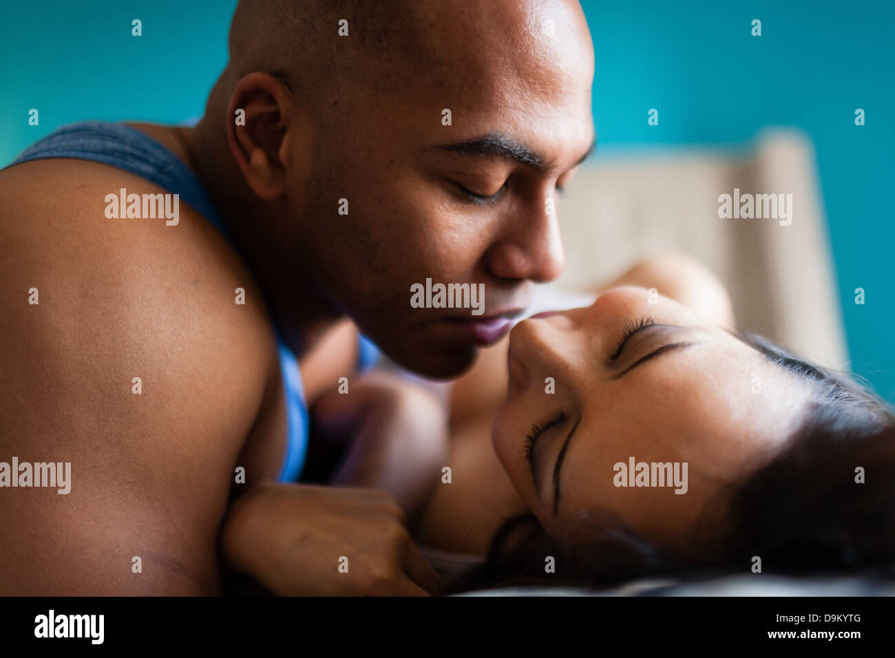 Mid adult couple kissing on bed Stock Photo