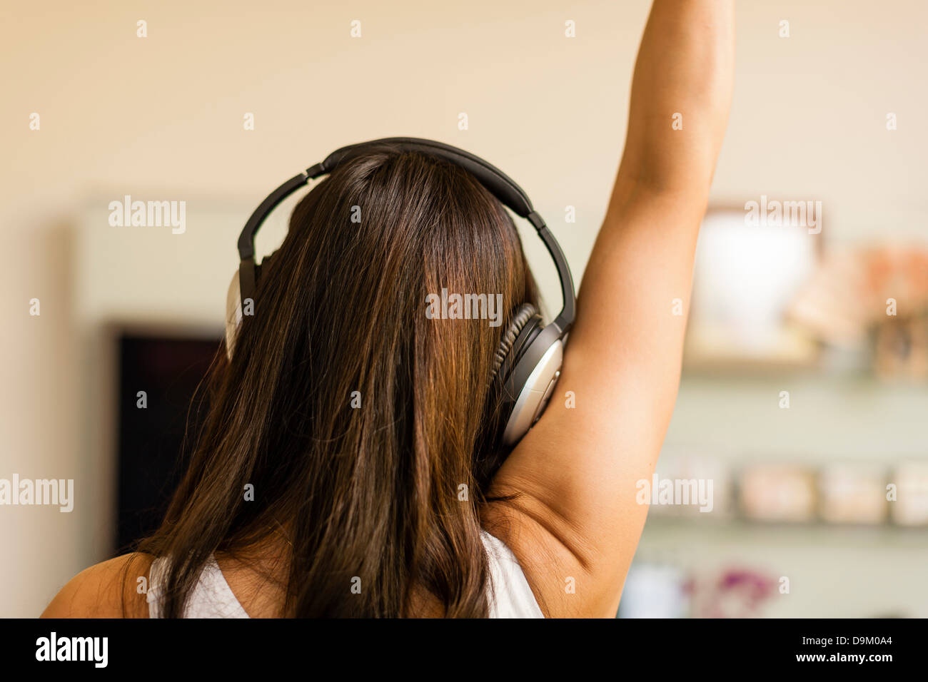 Mid adult woman wearing headphones and dancing, rear view Stock Photo