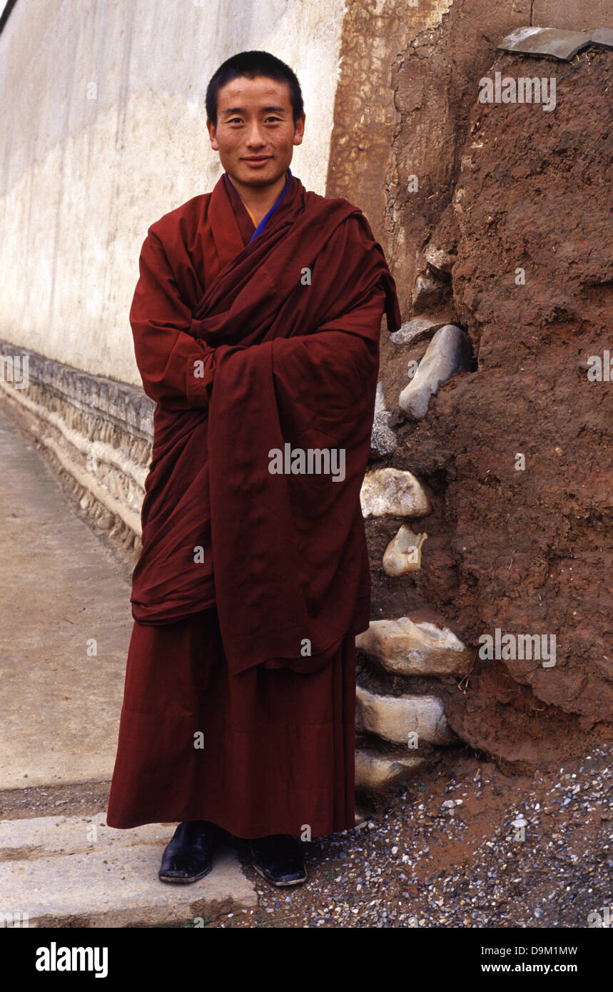 A Tibetan Buddhist novice wearing red mantle in the Tibetan gompa Kumbum Monastery also called Ta'er Temple founded in 1583 in a narrow valley close to the village of Lusar in the historical Tibetan region of Amdo in Huangzhong County, in Xining the capital of Qinghai province in western China Stock Photo