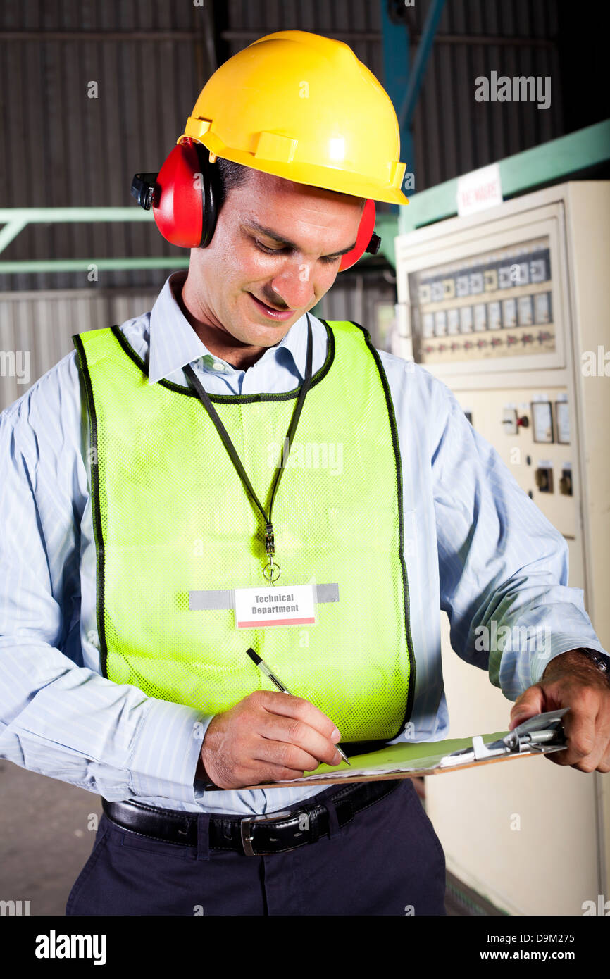 male industrial technician working inside a factory Stock Photo