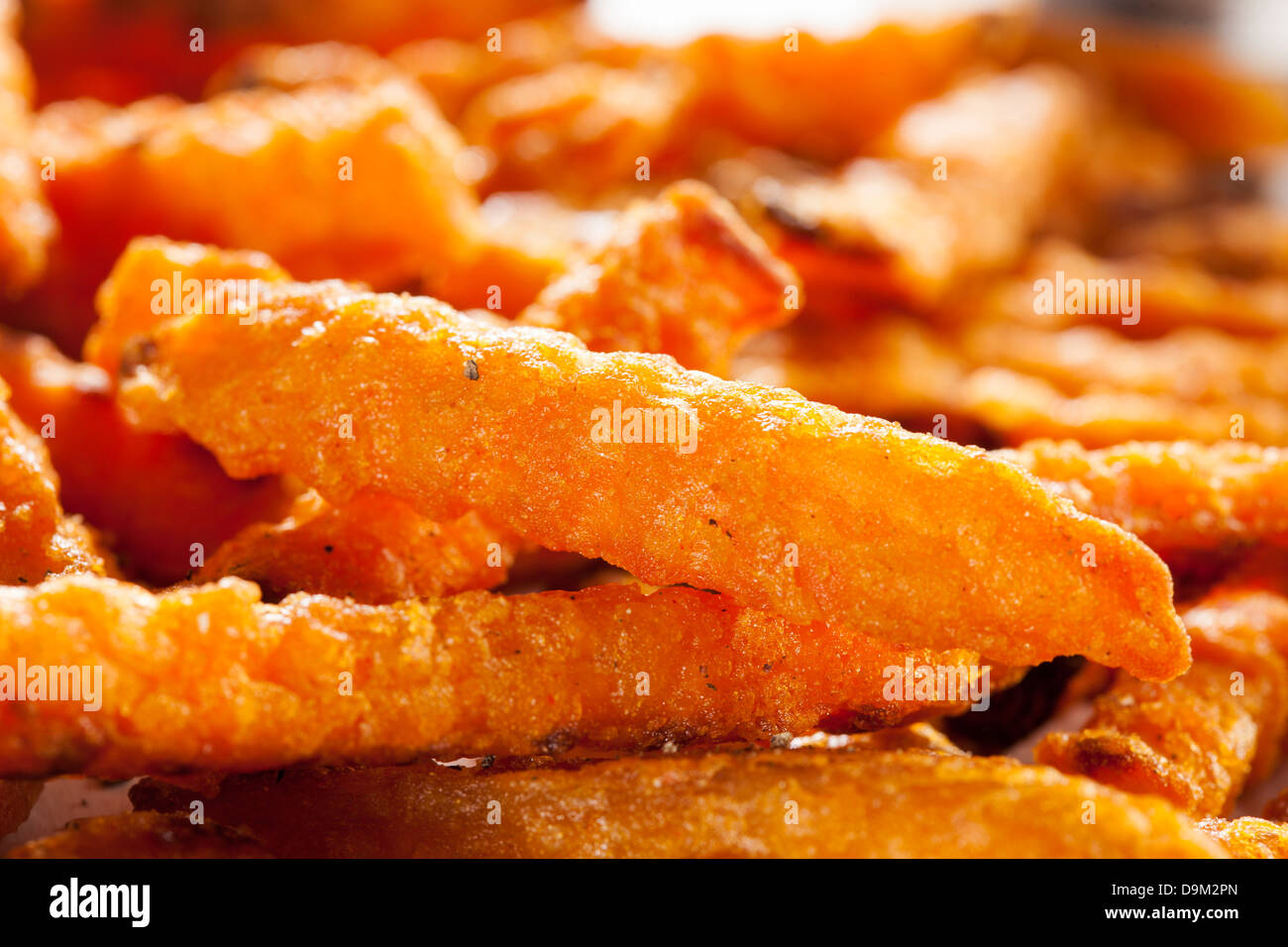 Cripsy Organic Sweet Potato Fries with pepper on parchment paper Stock Photo