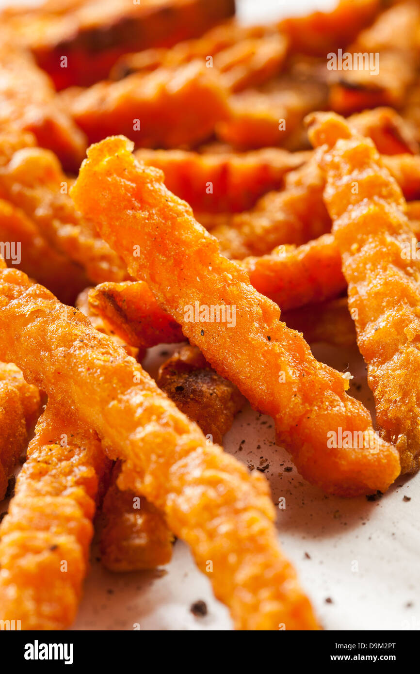 Cripsy Organic Sweet Potato Fries with pepper on parchment paper Stock Photo