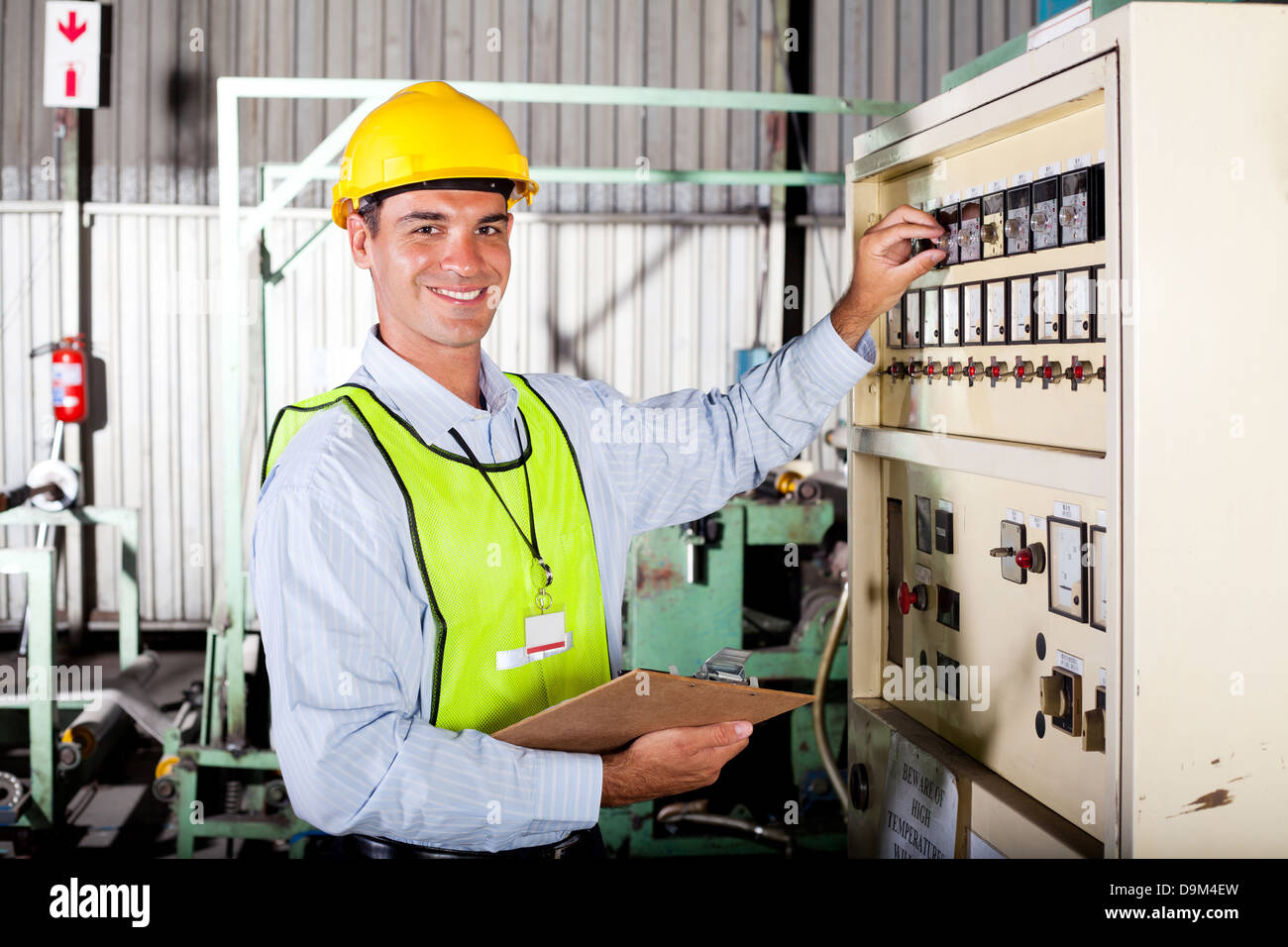 male Caucasian technician setting up industrial machine Stock Photo