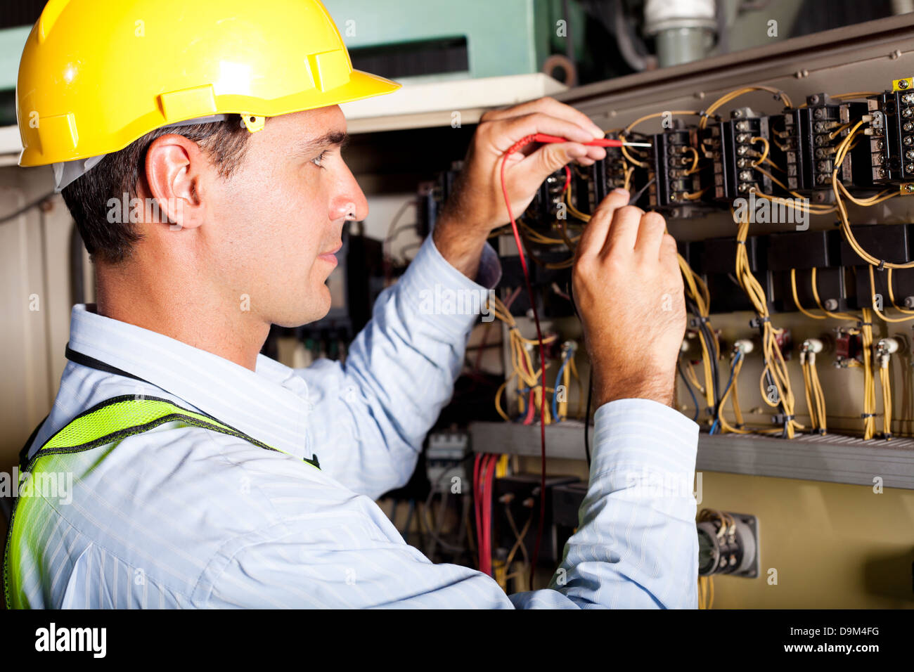 male electrician testing industrial machine Stock Photo