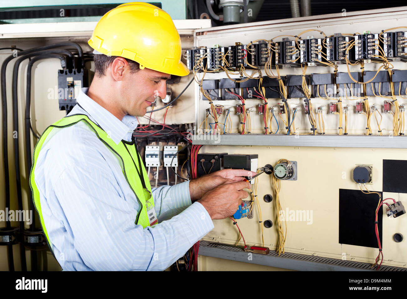 male caucasian electrician changing industrial machine switch Stock Photo