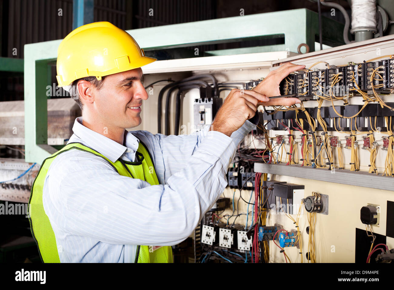 male electrician repairing industrial machine control component Stock Photo