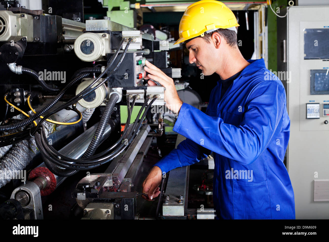 male Caucasian operator operating industrial printing press Stock Photo