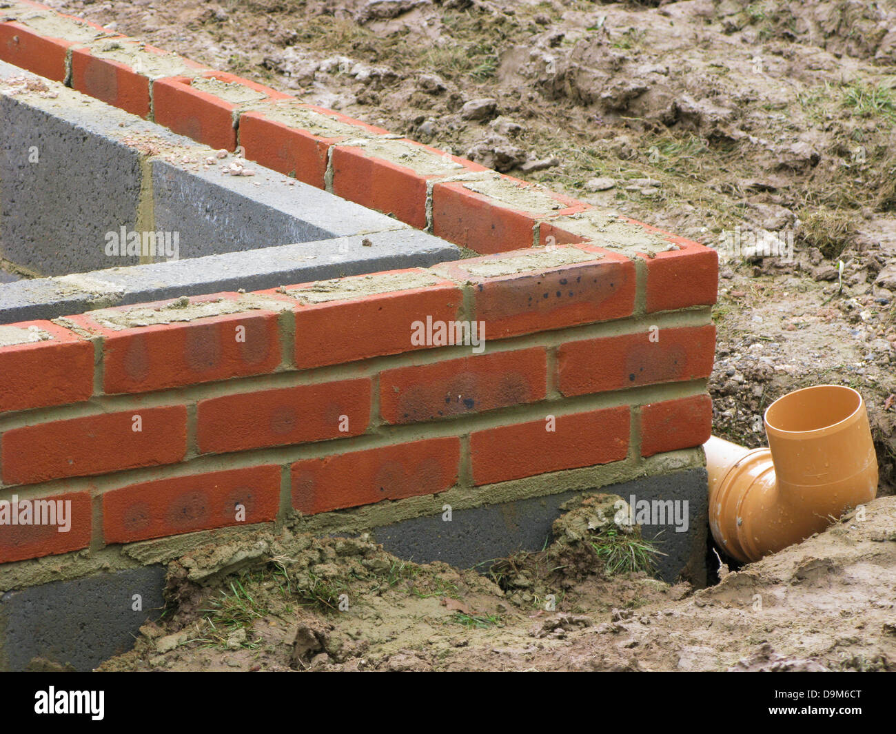 bricks & thermalite bricks built up to the damp course in a wall showing drainage system being