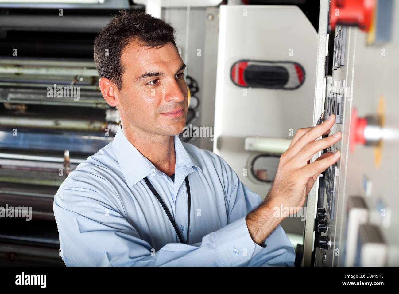male technician setting industrial machine in modern factory Stock Photo